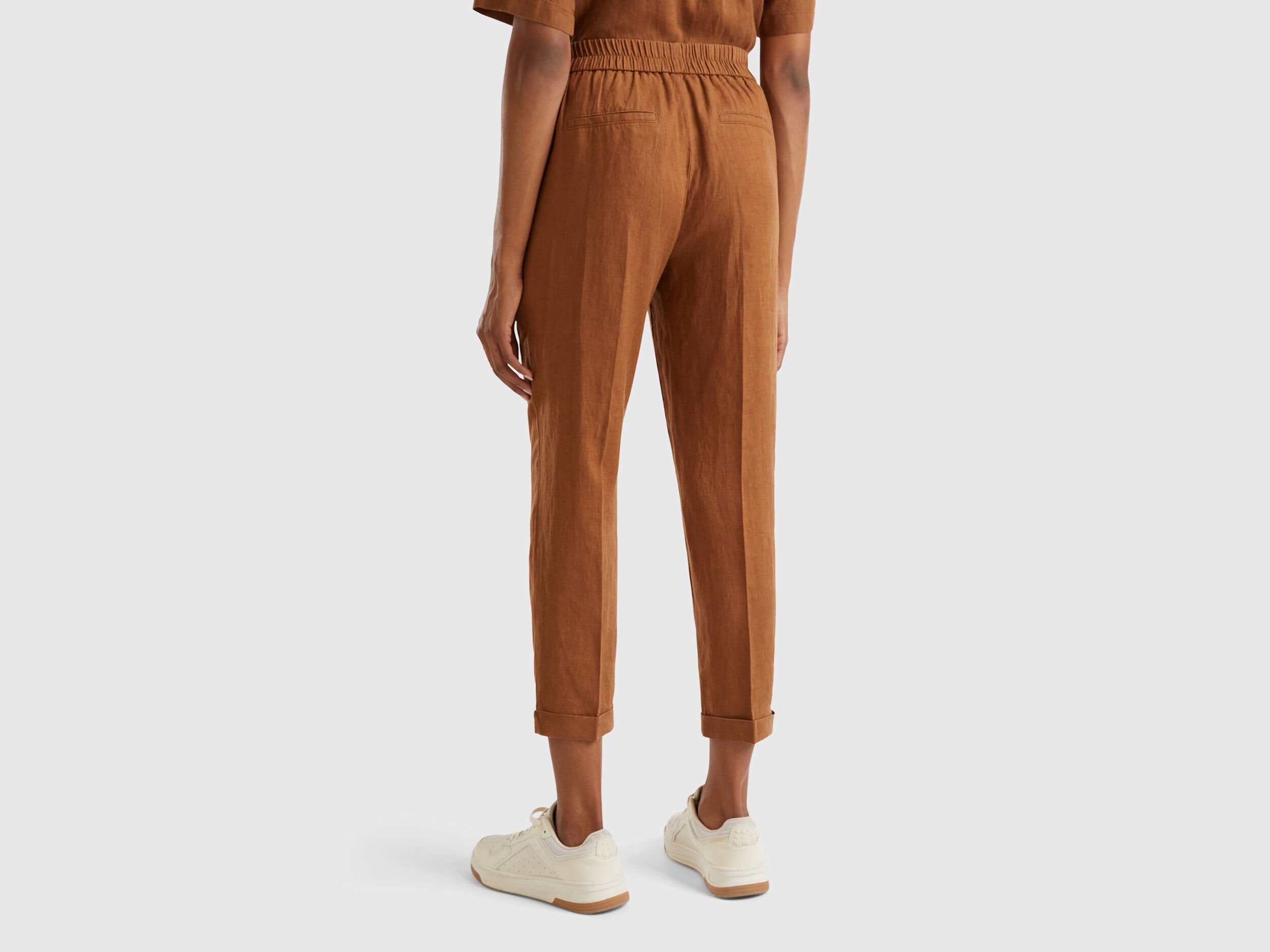 Side view of a female model wearing beige women&