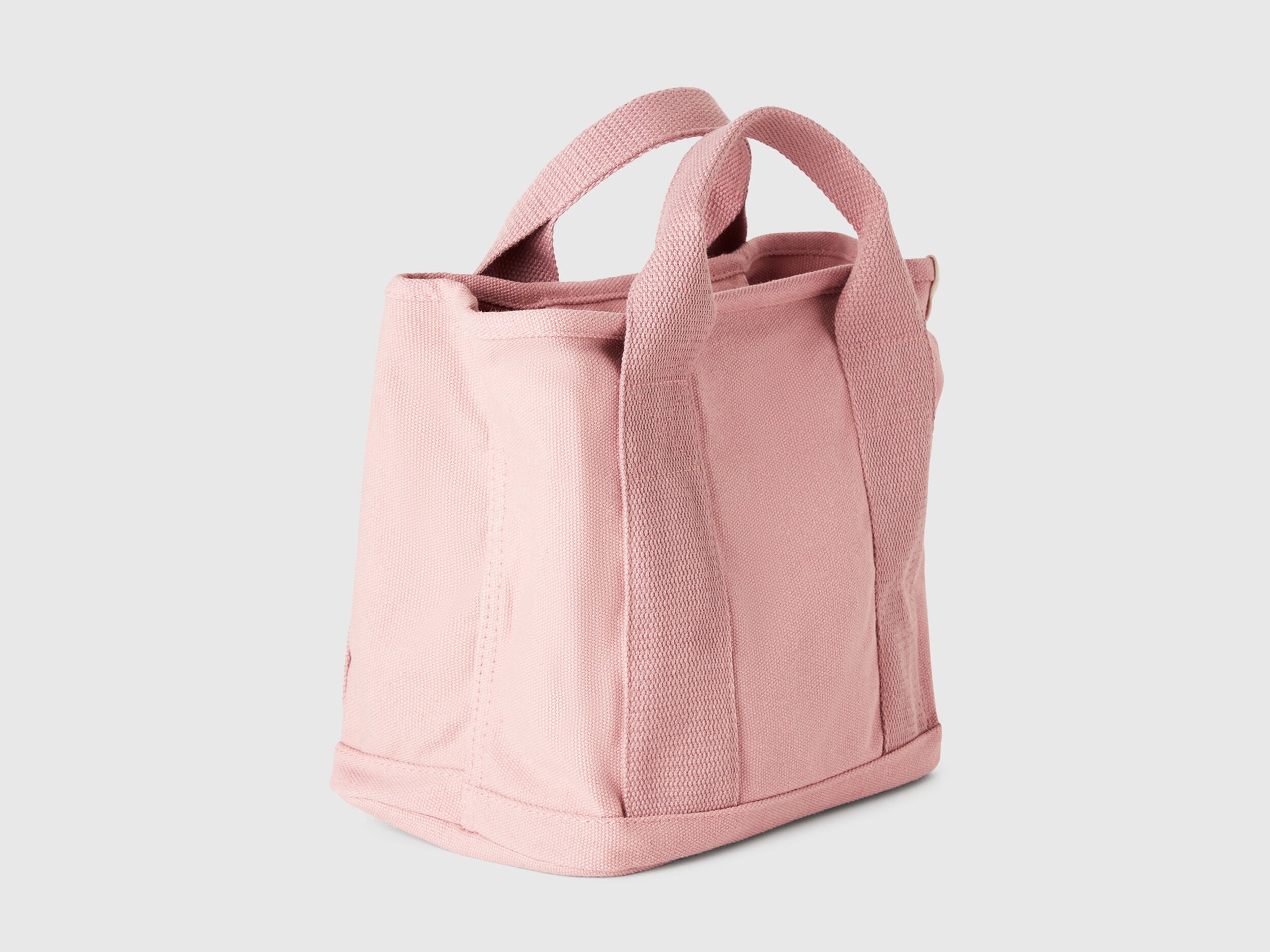 Angled view of a pink Benetton x Lilo & Stitch Disney bag, showcasing its textured fabric and structured design.