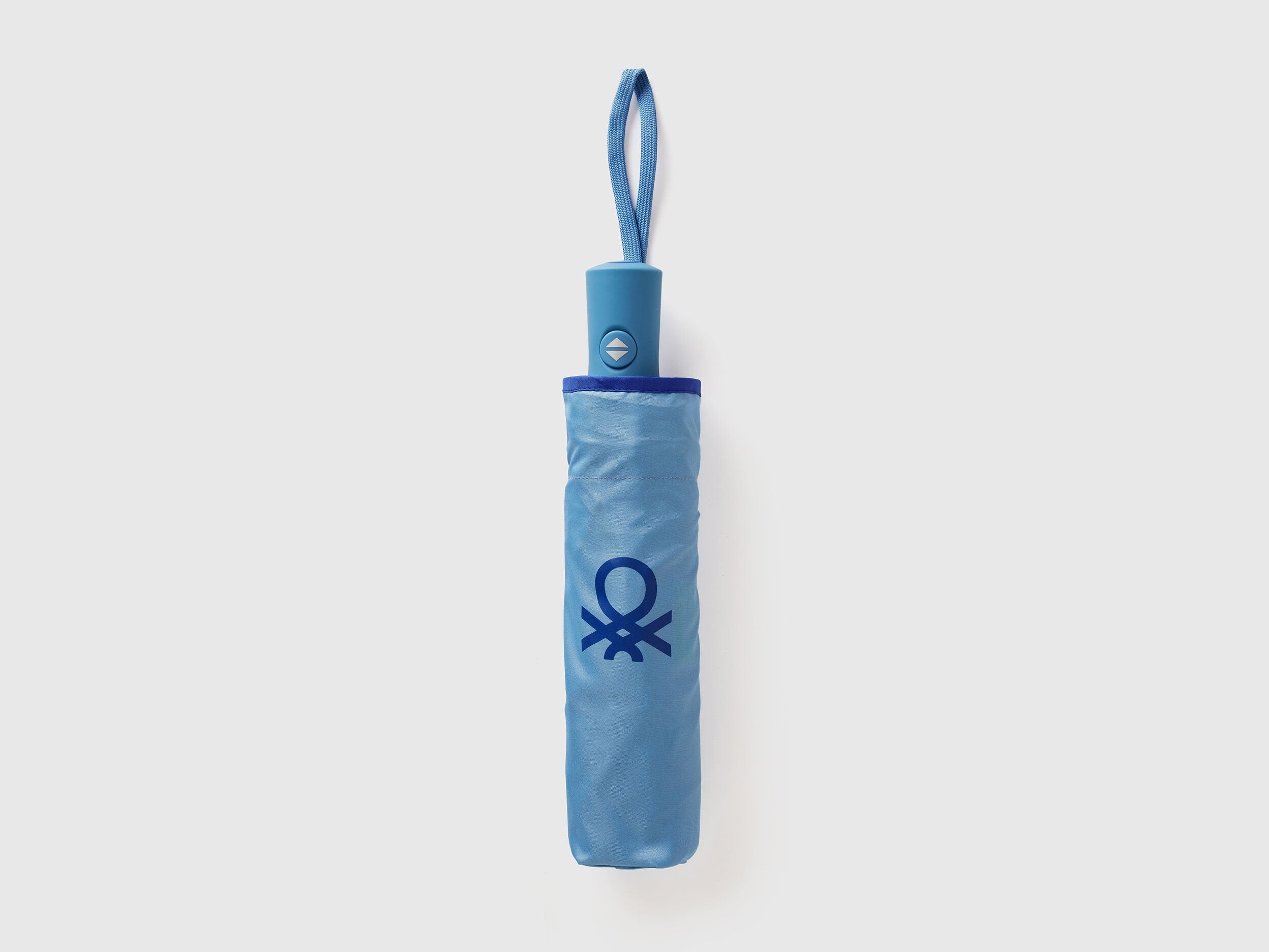 Folded blue Benetton umbrella, compact for travel.