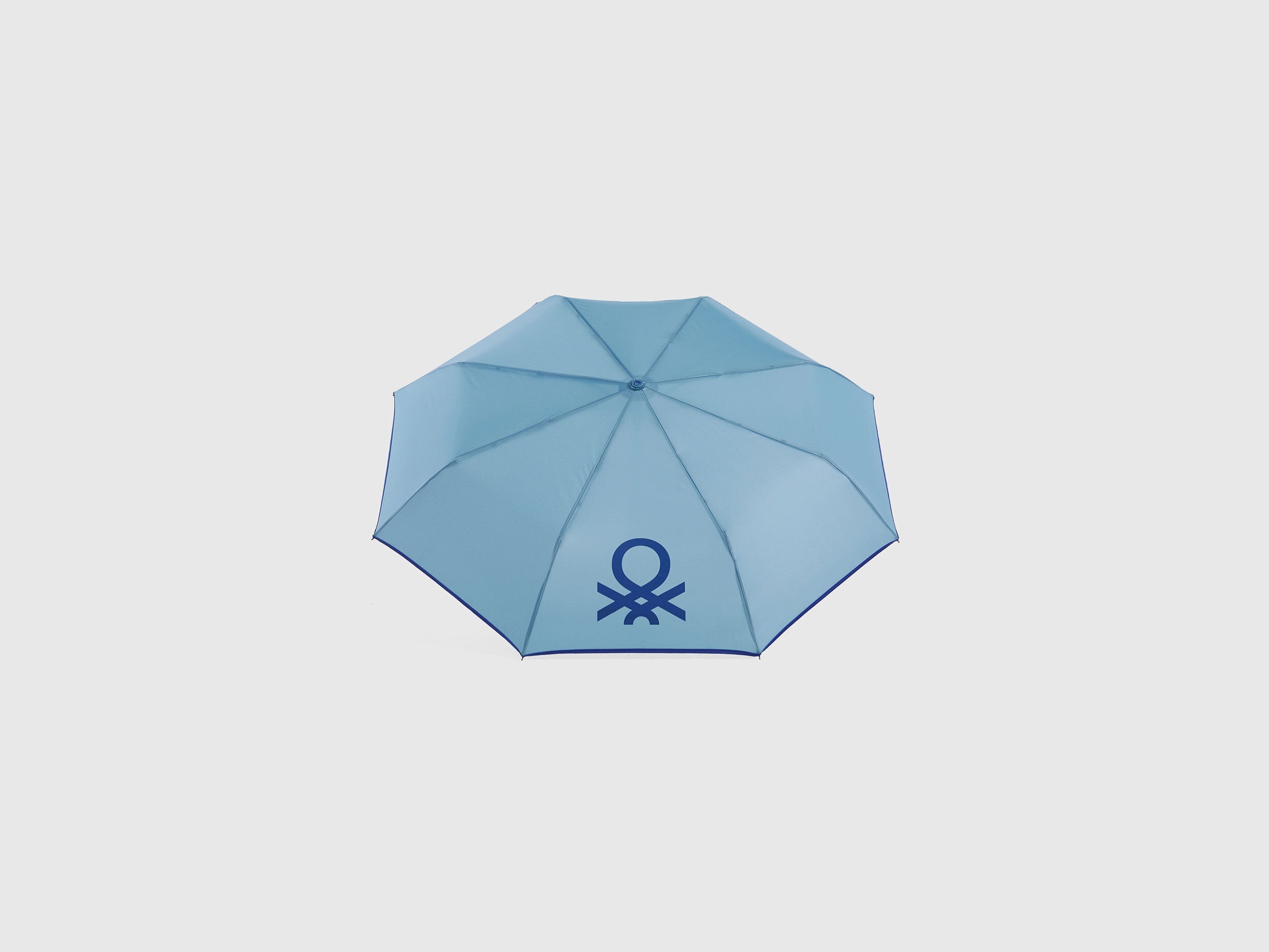 Open blue Benetton umbrella, top view for rain protection.