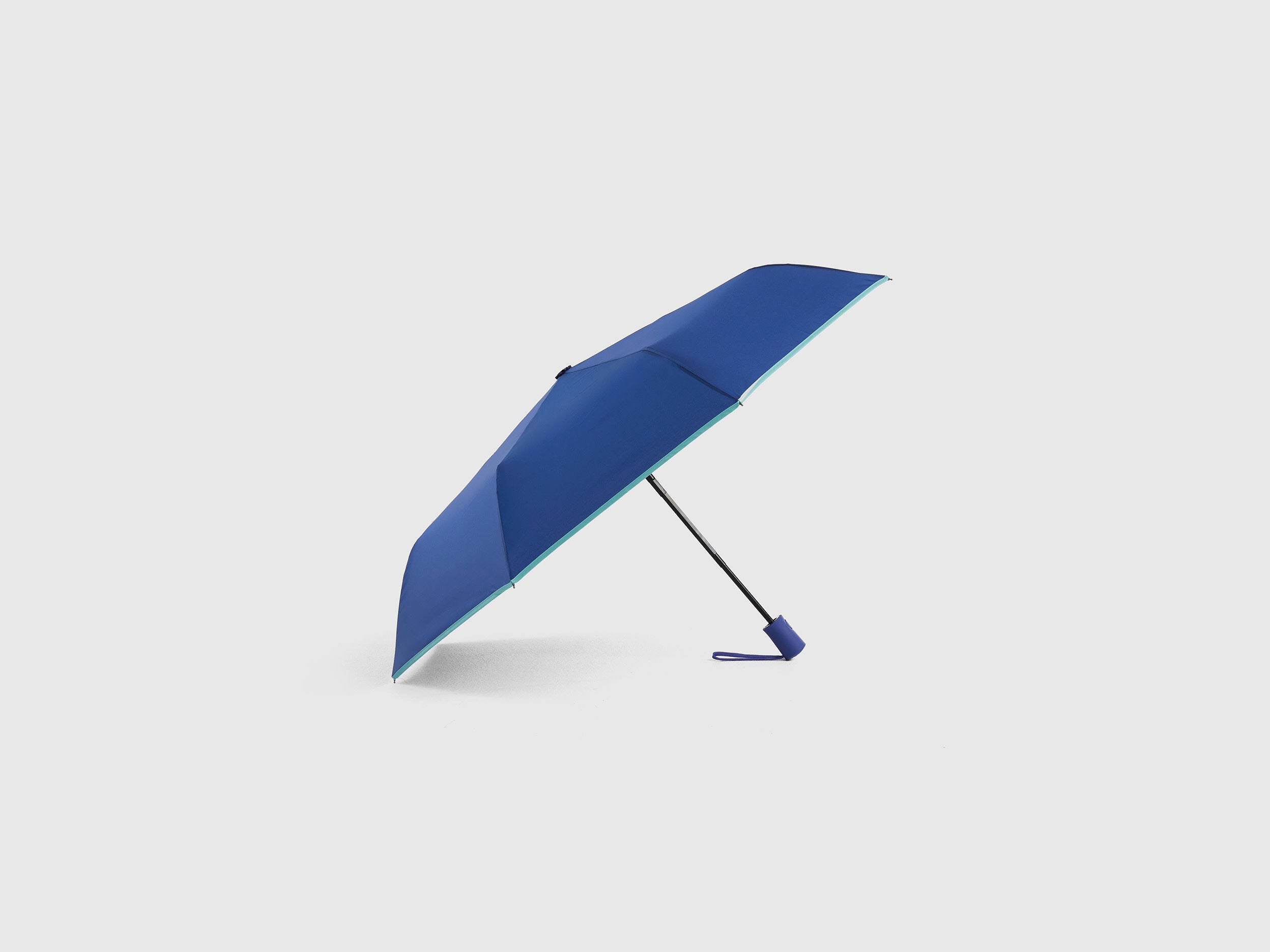 Close-up detail of the handle and clasp of a blue umbrella.