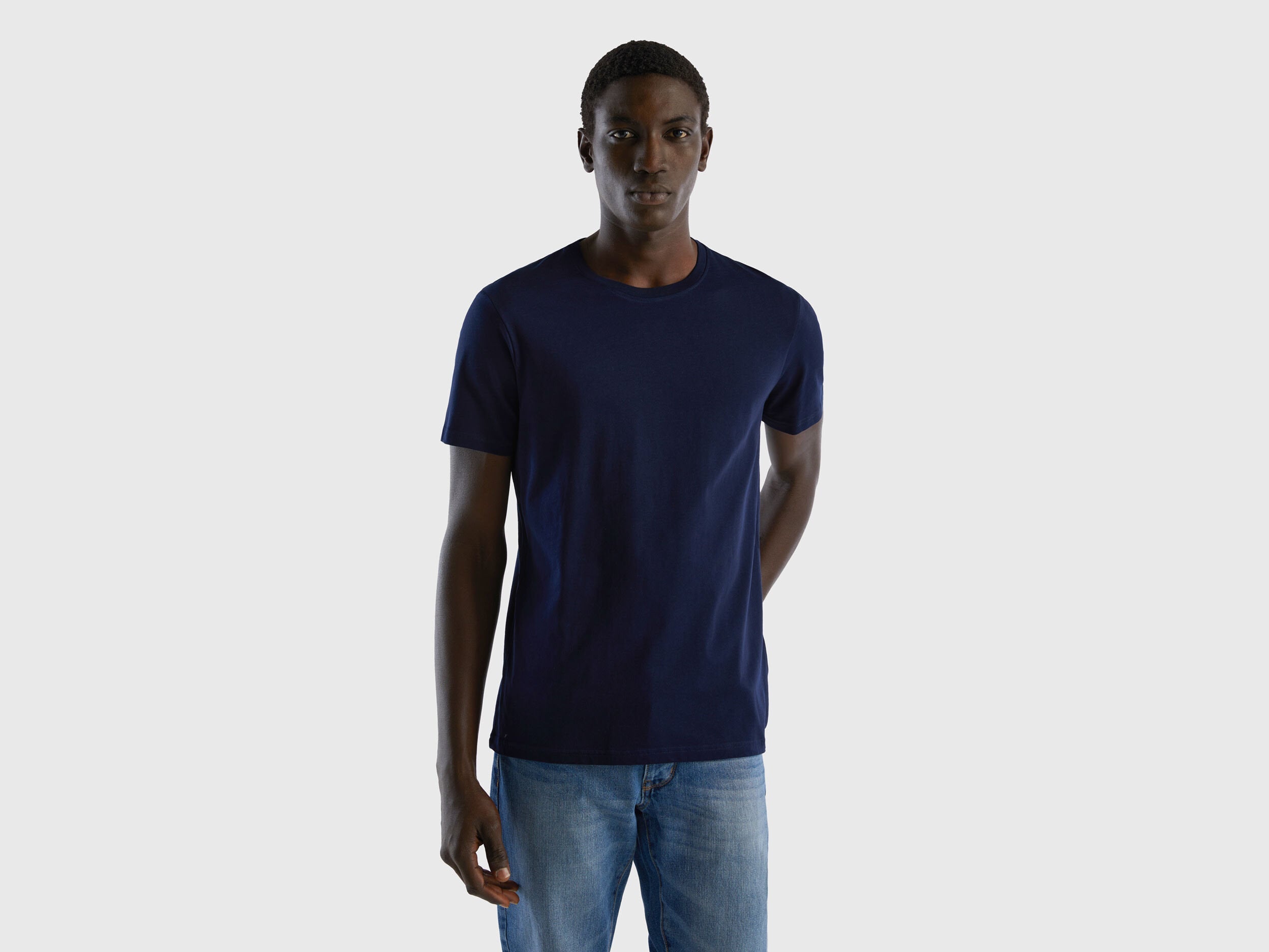 Front view of a man wearing a dark blue t-shirt and jeans. Casual, everyday look.