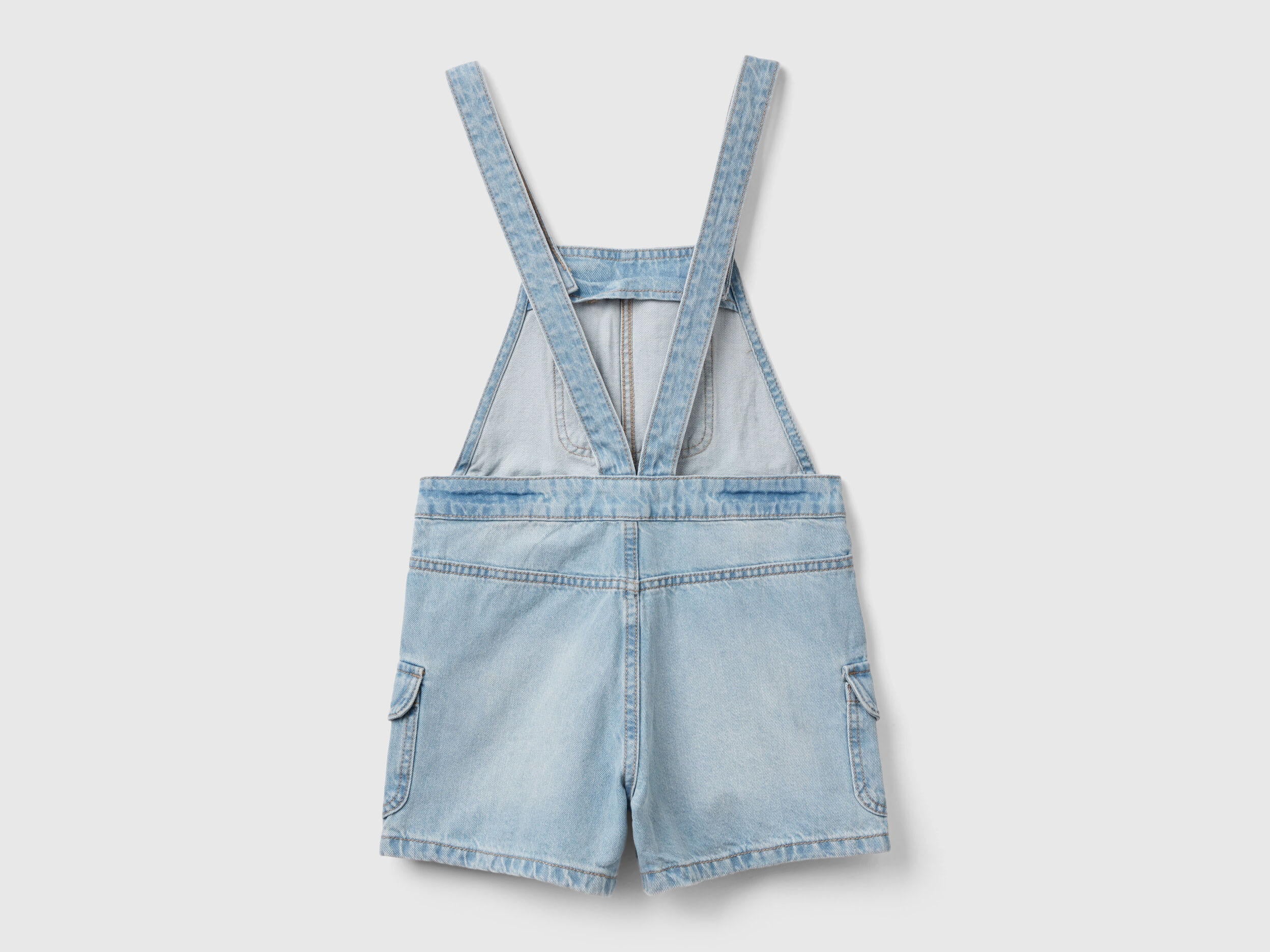 Back view of light wash denim dungaree shorts for girls in Kuwait.