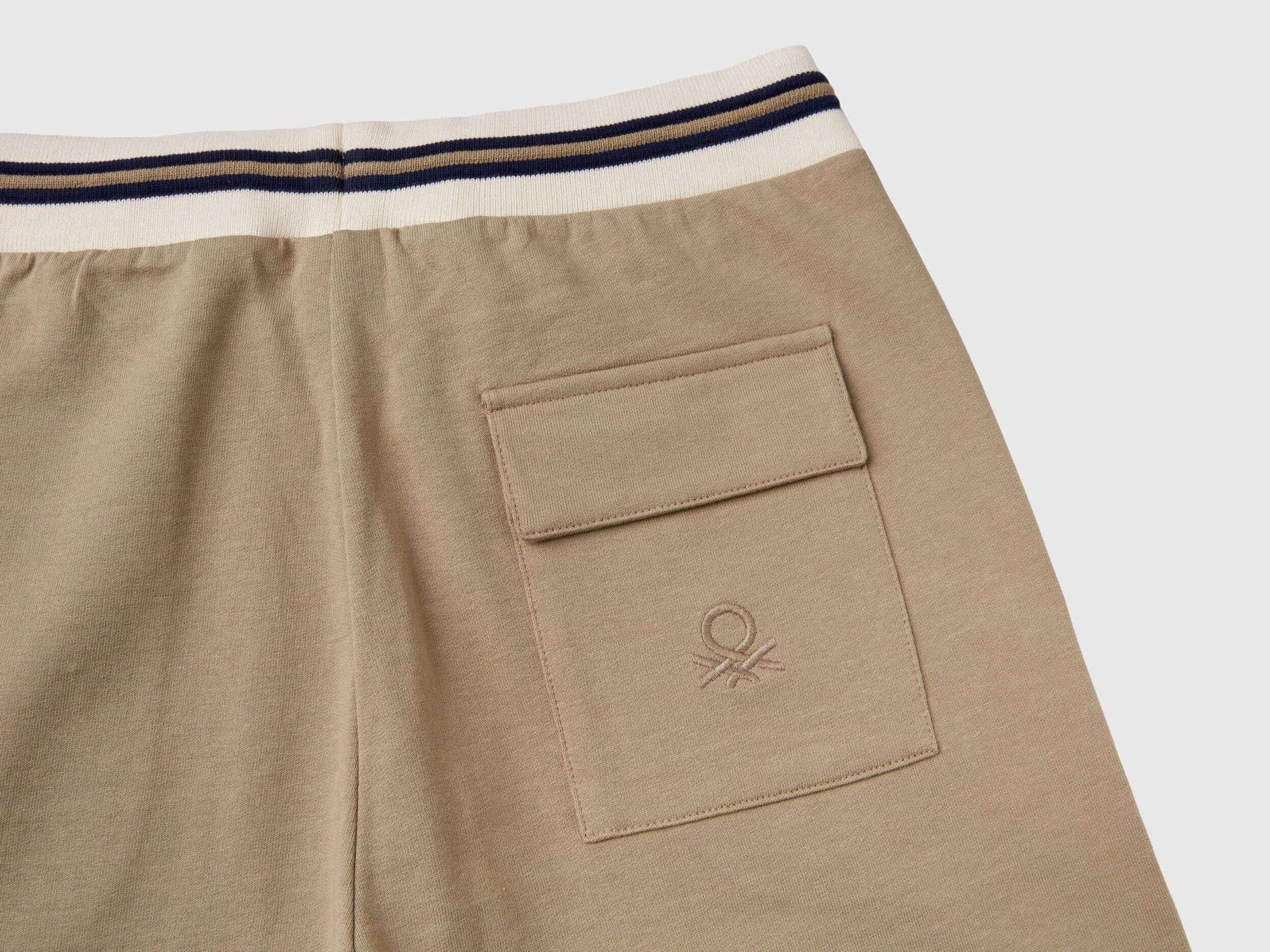 Close-up of the pocket detail on lightweight beige sweat shorts.