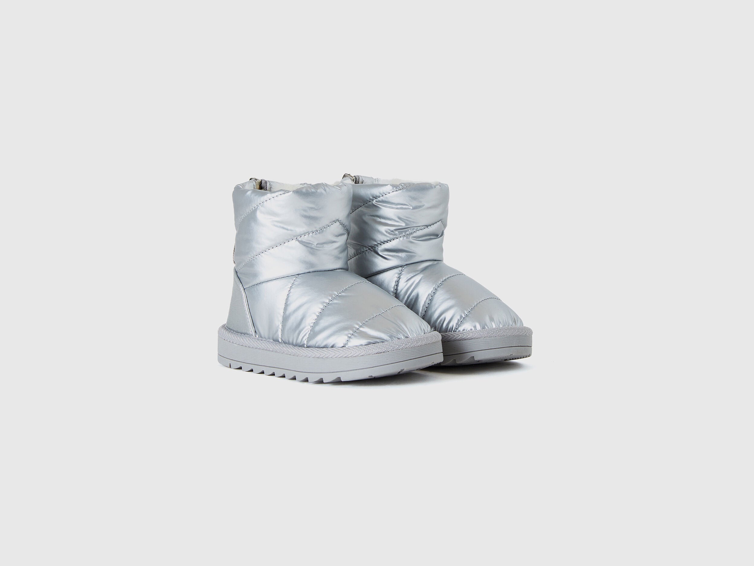 A pair of shiny silver Nylon Ankle Boots with a quilted design and durable soles, perfect for cooler weather in Kuwait.