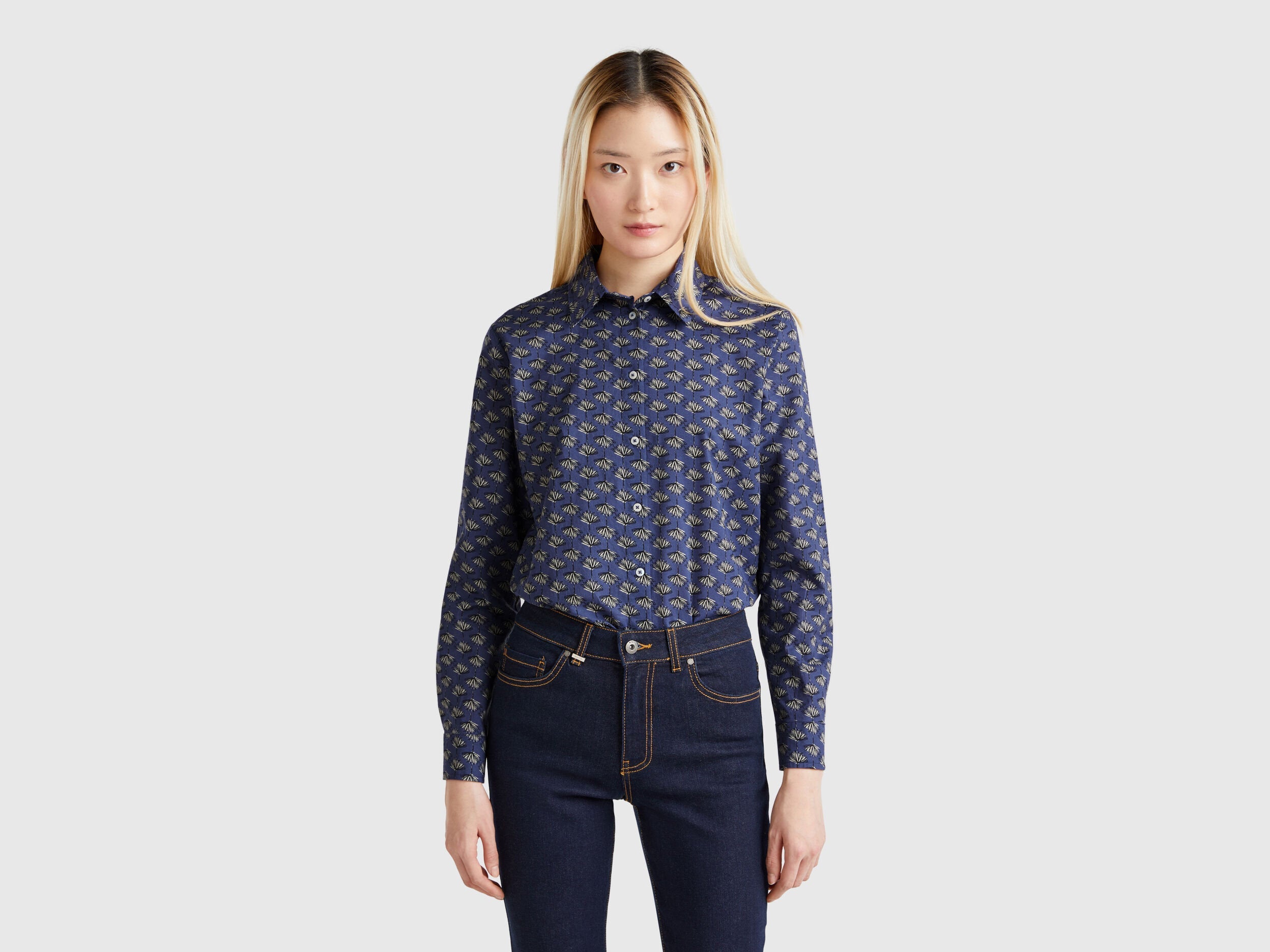 Side view of a model wearing a dark blue patterned shirt for women in Kuwait.