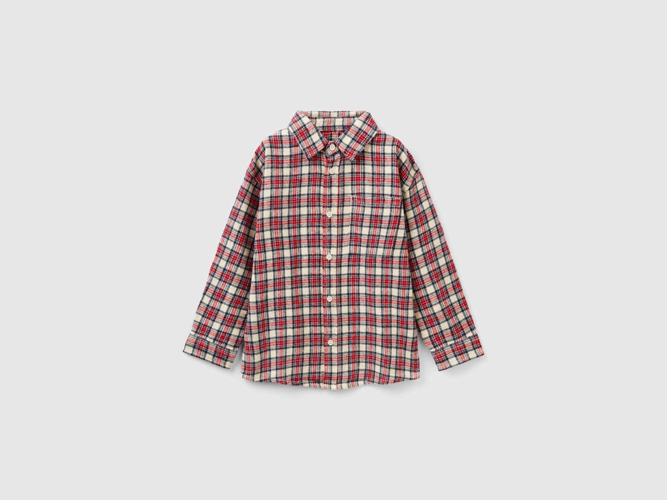 A Boys model wearing long-sleeve checked shirt over a white T-shirt, a classic casual look for Kuwait.