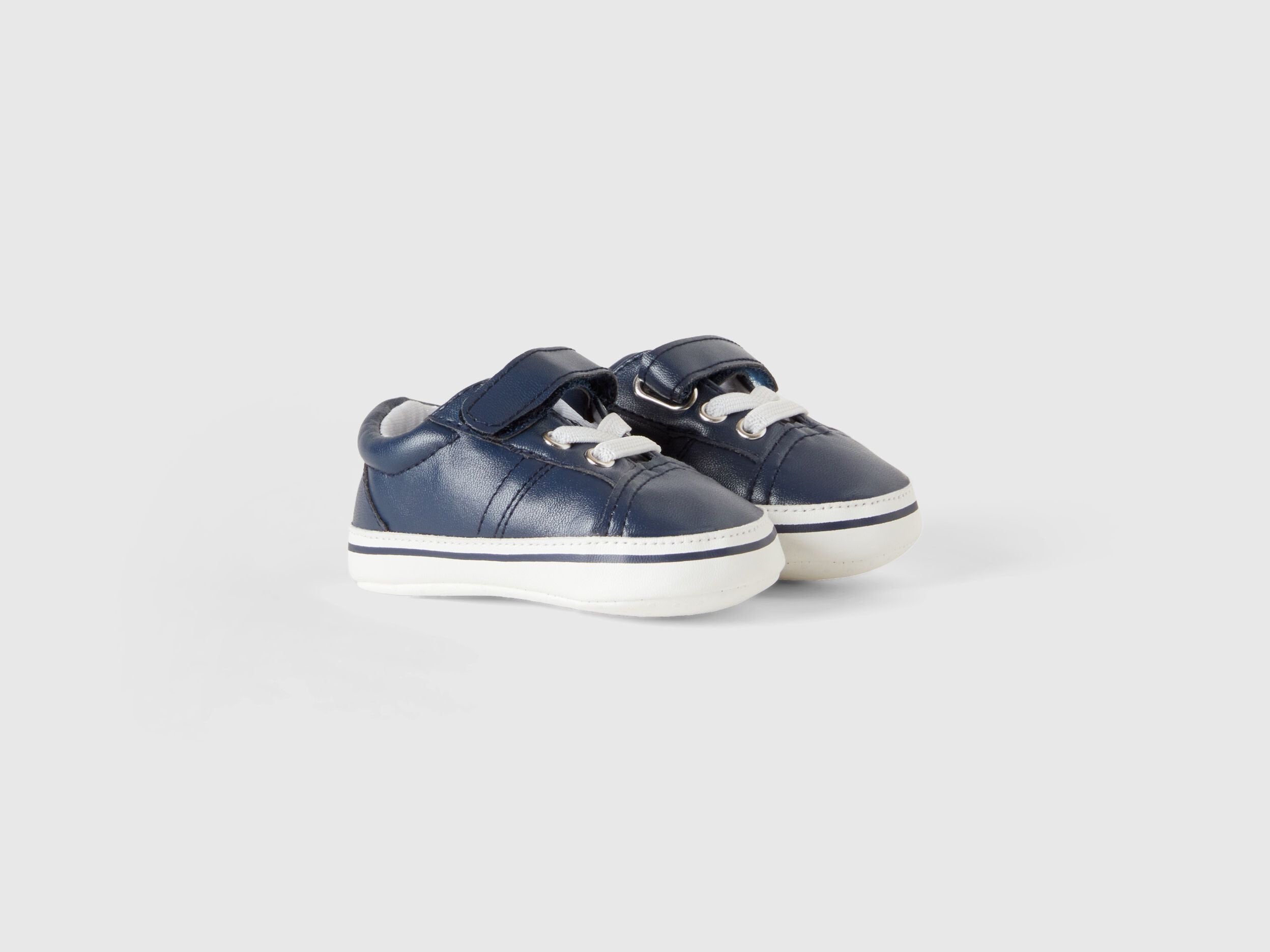 A pair of first-step kids shoes with white soles and velcro straps, suitable for young children in Kuwait.