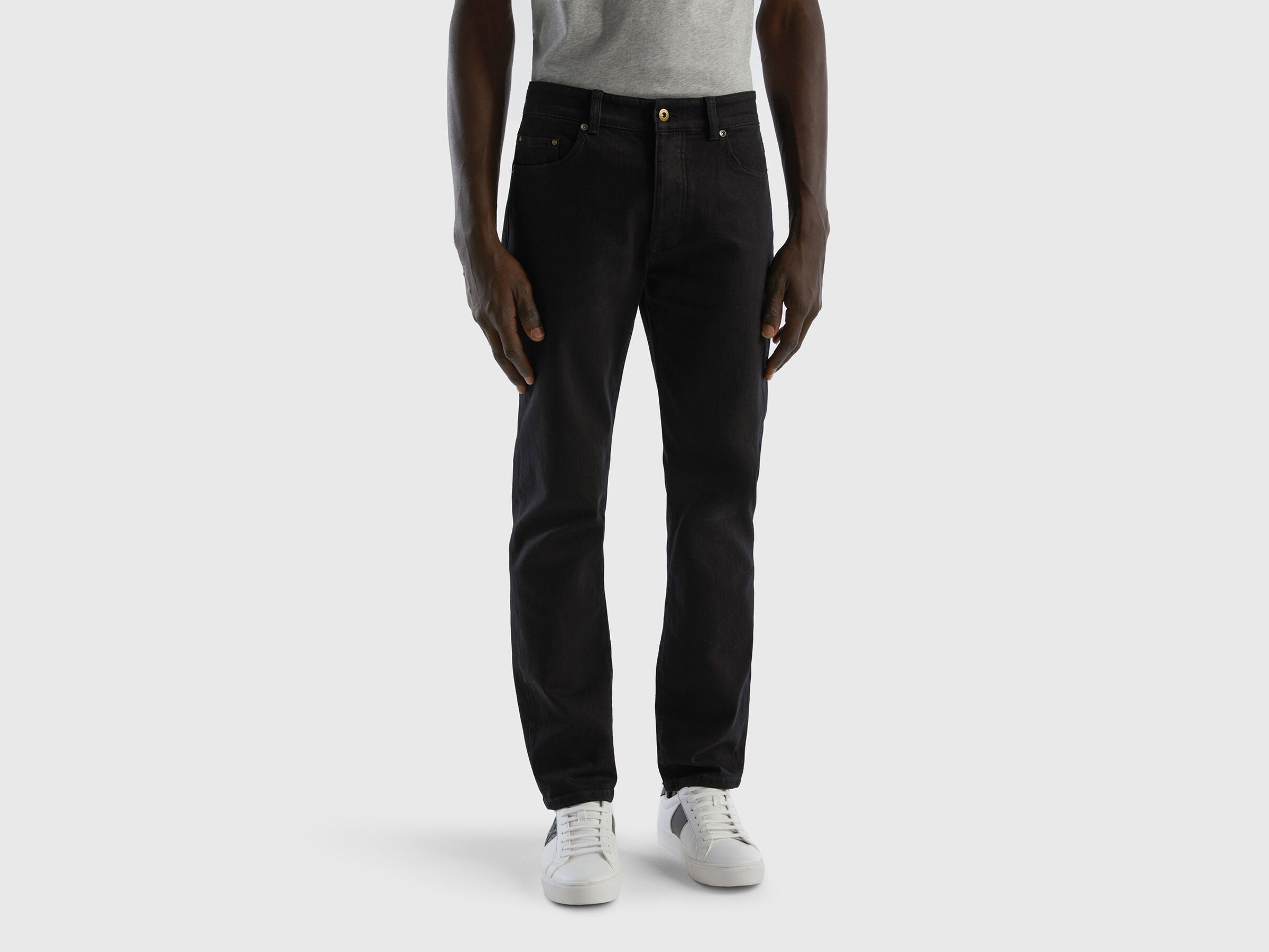 Full-length back view of a man wearing black slim-fit jeans.