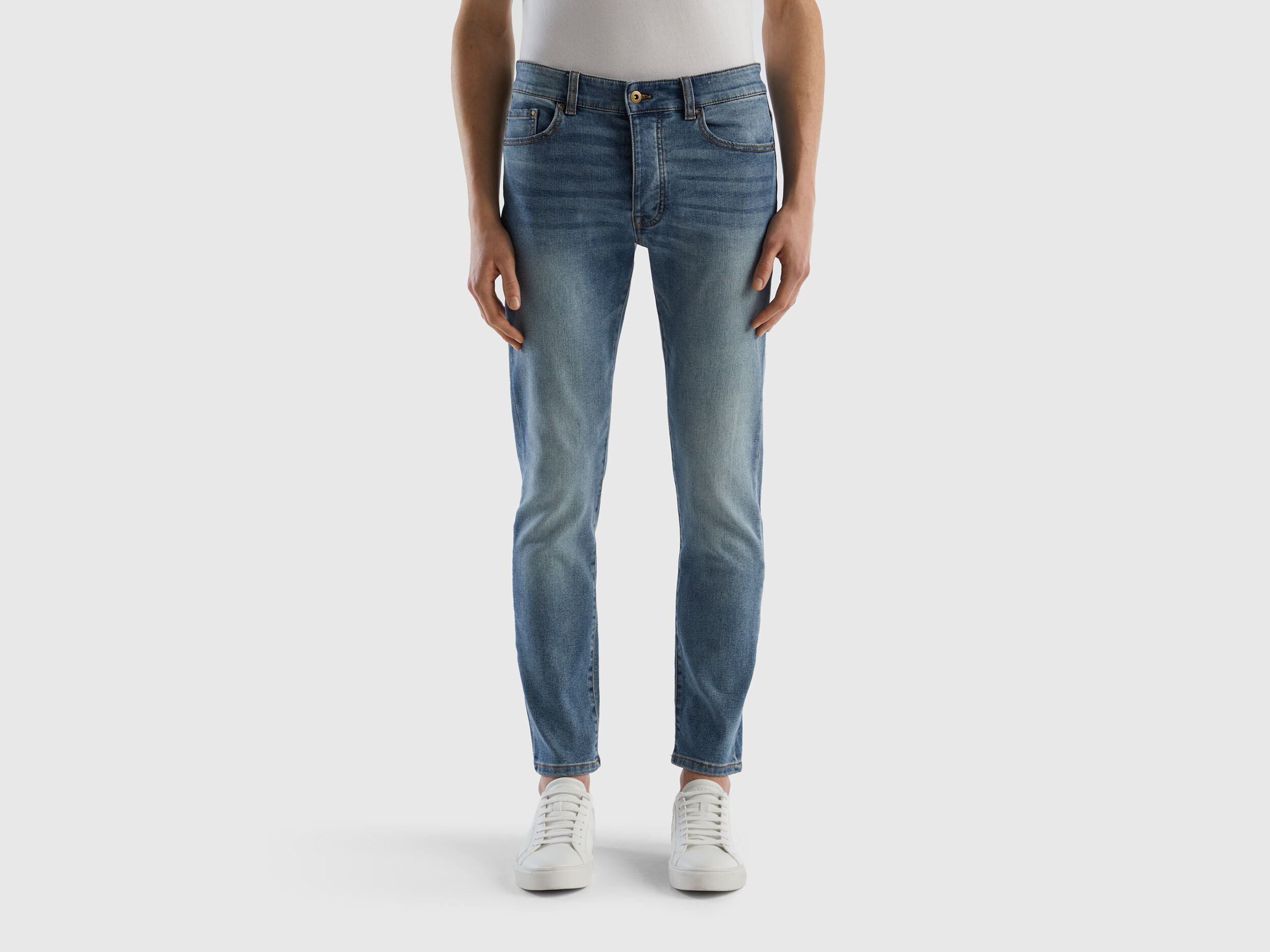 Back view of a man wearing black slim-fit jeans.