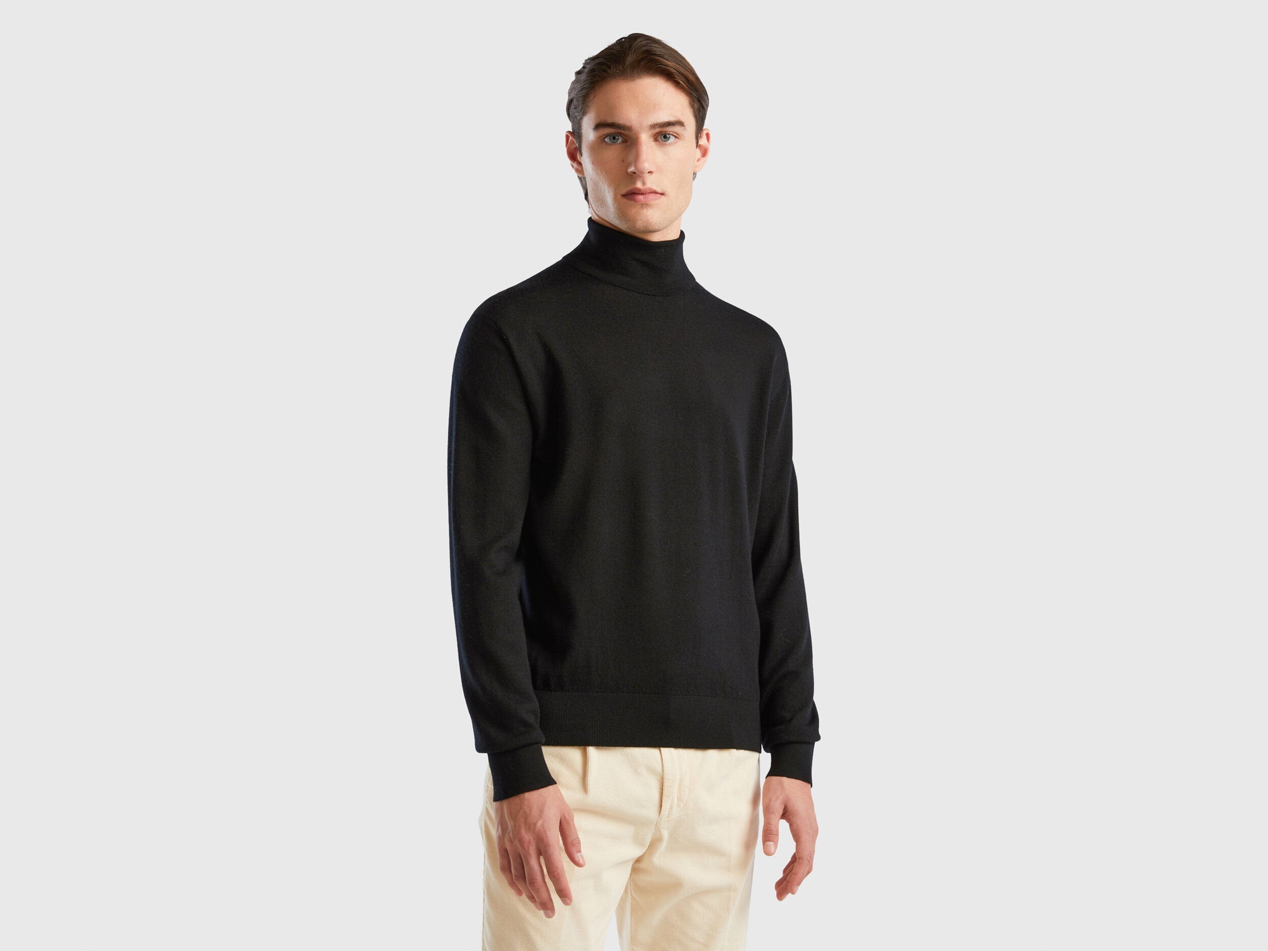 Front view of a man wearing a black turtleneck sweater.