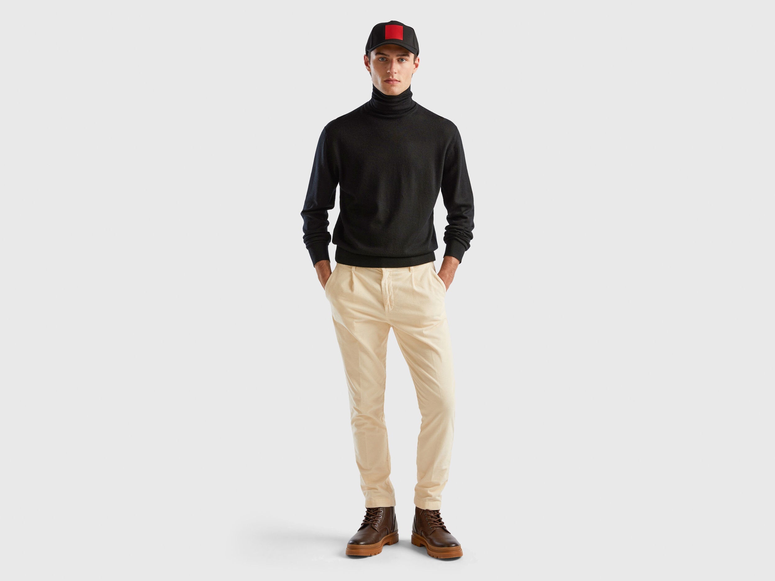 Side view of a man wearing a black turtleneck sweater.