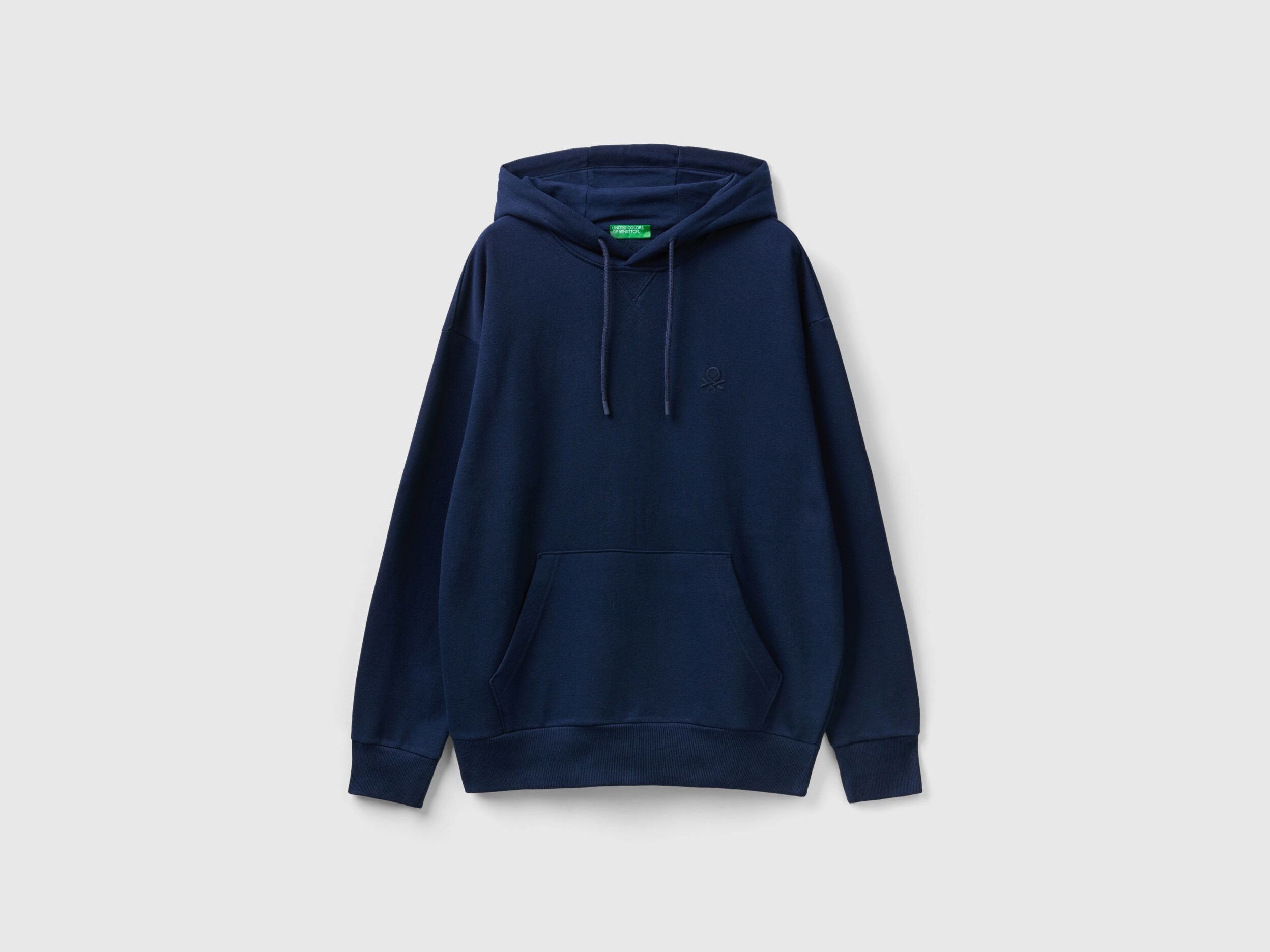 Side view of a man wearing a plain blue pullover hoodie.