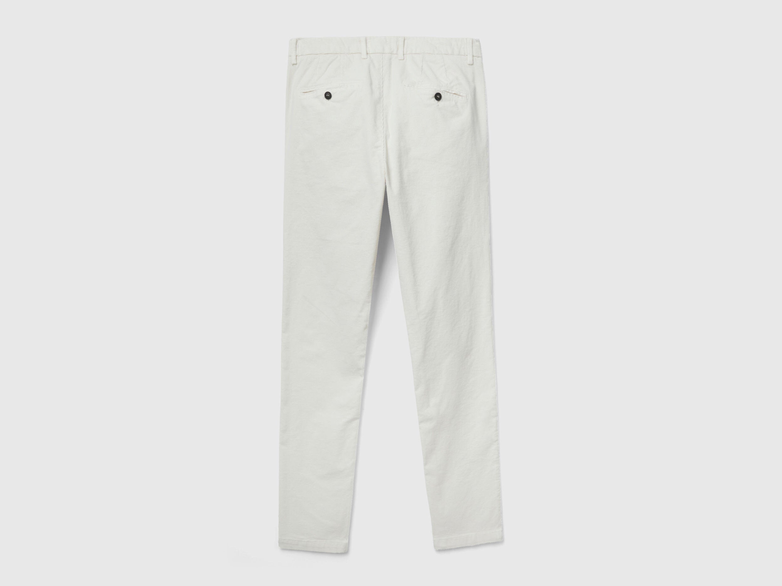 Flat lay, back view of a pair of plain white stretch velvet trousers, showing pocket details and fabric, a staple among velvet jeans for men in Kuwait.