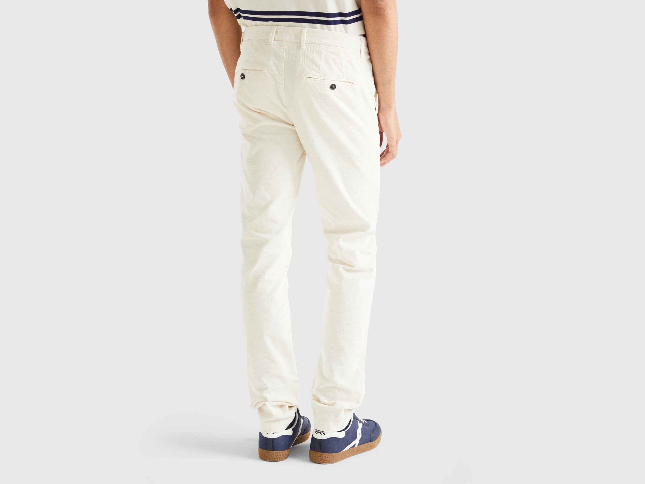 Back view of a male model showcasing slim-fit white stretch velvet trousers, highlighting the comfortable fit of velvet jeans for men in Kuwait.