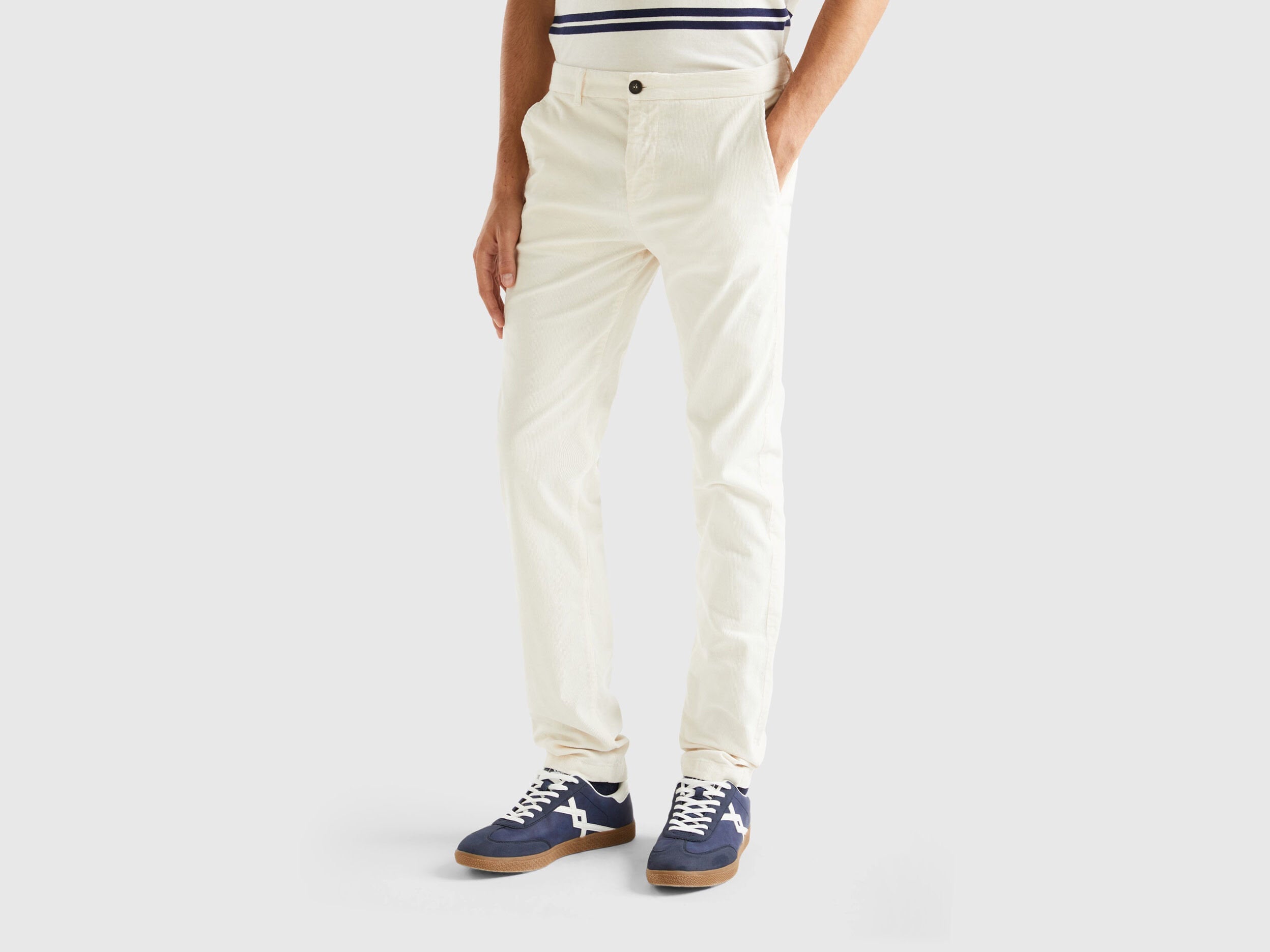 Front view of a male model wearing slim-fit white stretch velvet trousers, demonstrating the cut and fabric of velvet jeans for men in Kuwait.