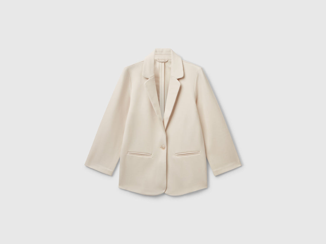 Front view of a light beige elegant long blazer. Tailored fit with two buttons and classic lapels.