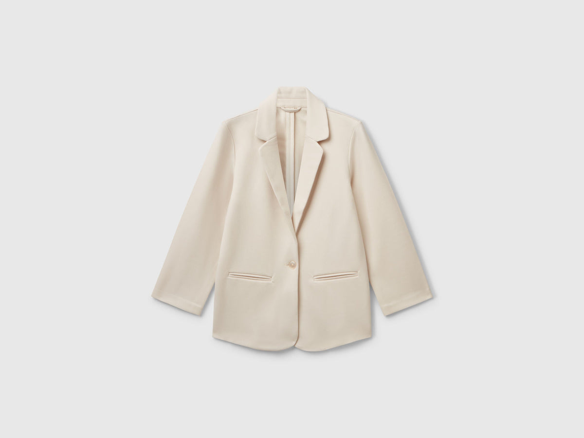 Front view of a light beige elegant long blazer. Tailored fit with two buttons and classic lapels.