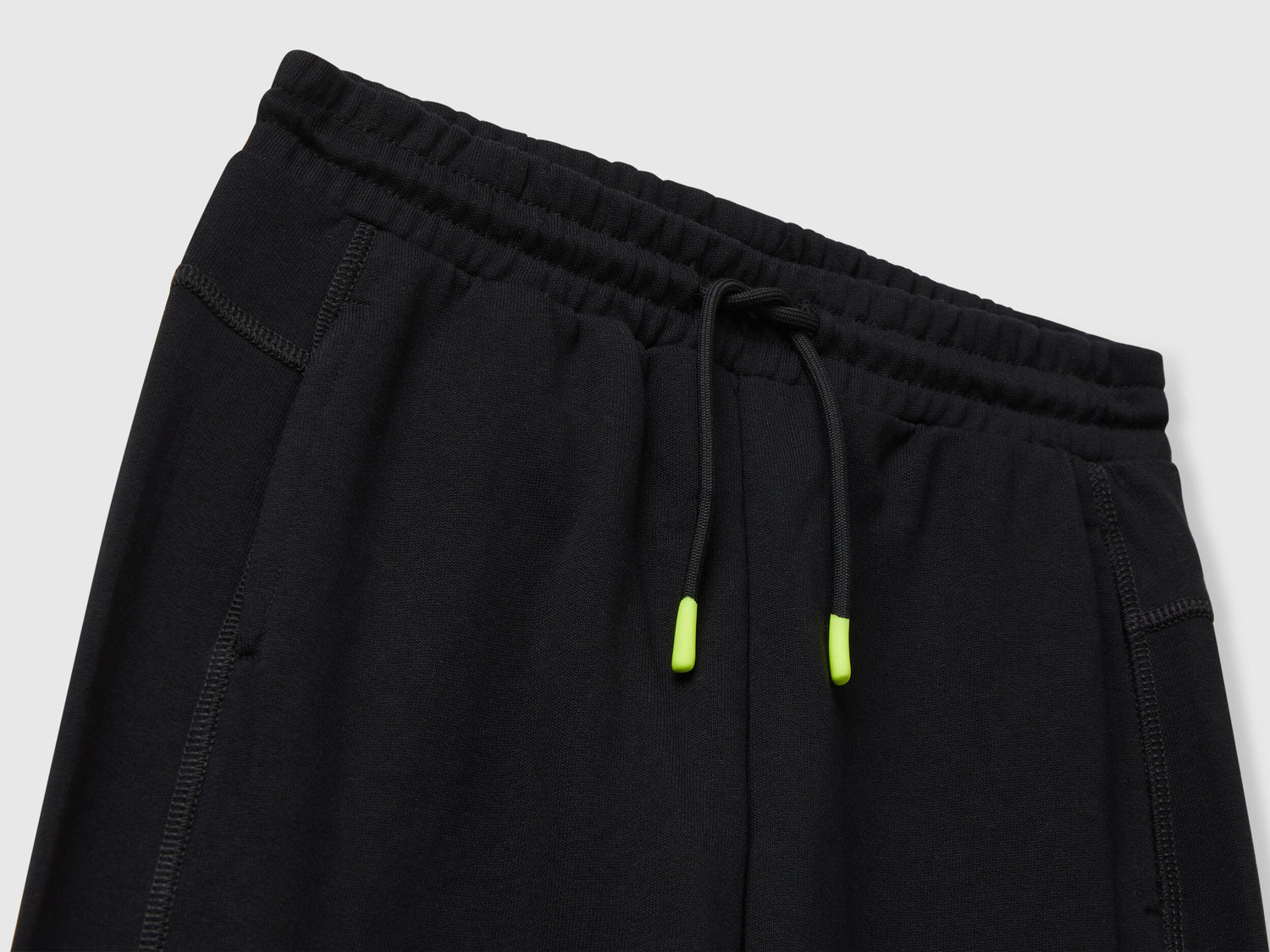 Benetton black cotton sweatpants side view showing elastic bottom and fit.