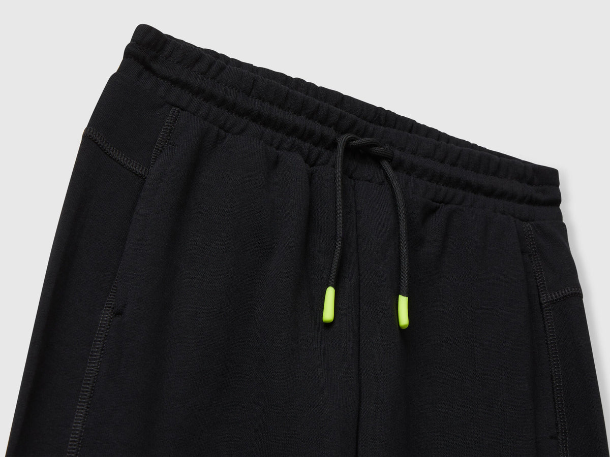 Benetton black cotton sweatpants side view showing elastic bottom and fit.