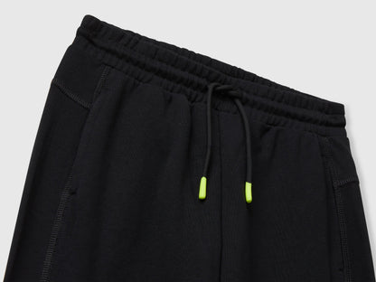 Benetton black cotton sweatpants side view showing elastic bottom and fit.