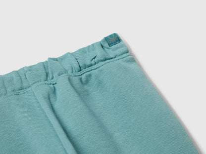 Benetton blue cotton joggers side view showing elastic waist detail.