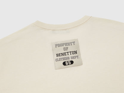 Close-up of the red and white Benetton logo on a dark blue checkered jacket.