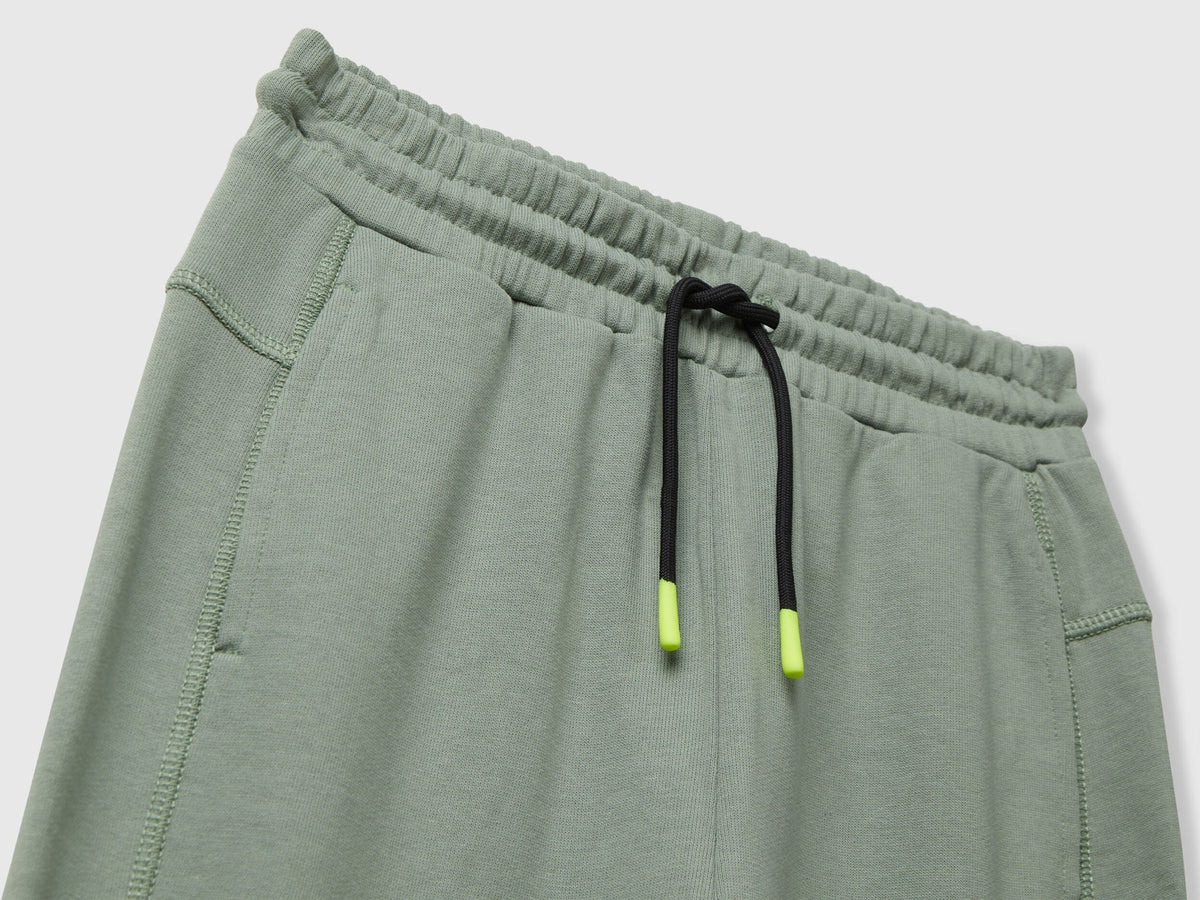 Benetton green cotton sweatpants side view showing elastic bottom and fit