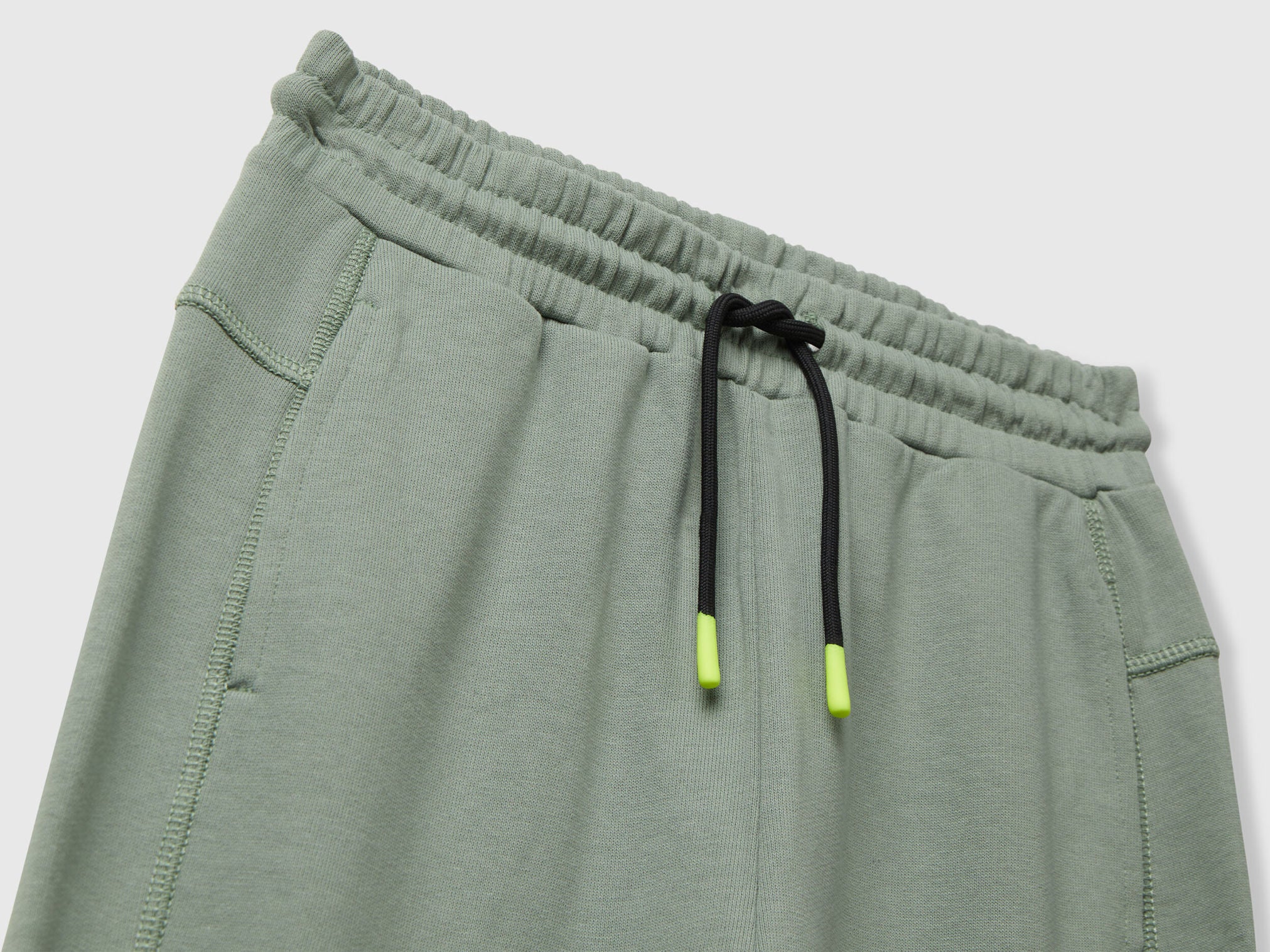 Benetton green cotton sweatpants side view showing elastic bottom and fit