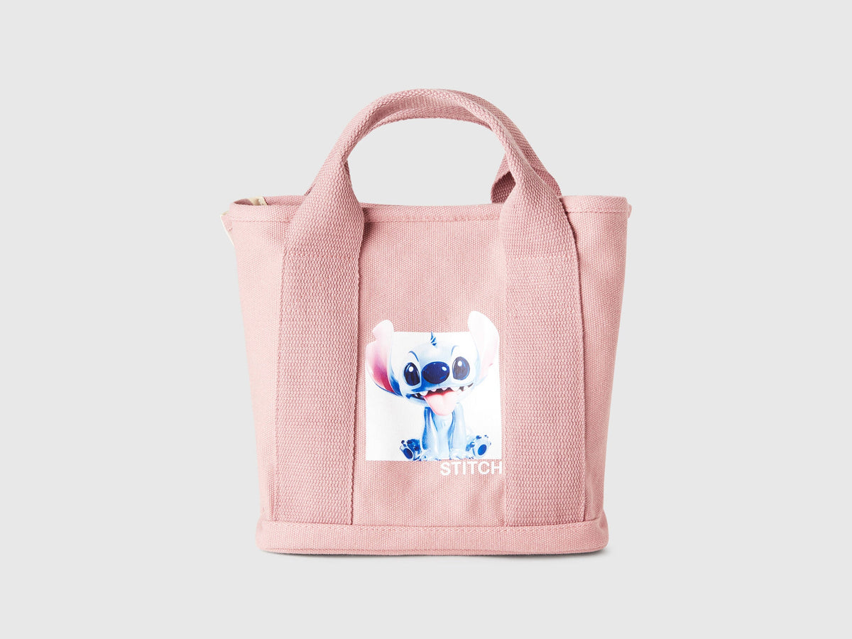 Front view of a pink Benetton x Lilo &amp; Stitch Disney tote bag, featuring a clear graphic of Stitch, perfect for fans.