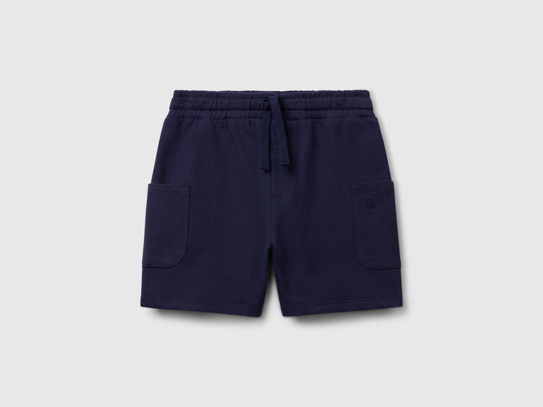 Angled view of navy blue Benetton cotton cargo shorts, showcasing the drawstring waist and practical side pockets.