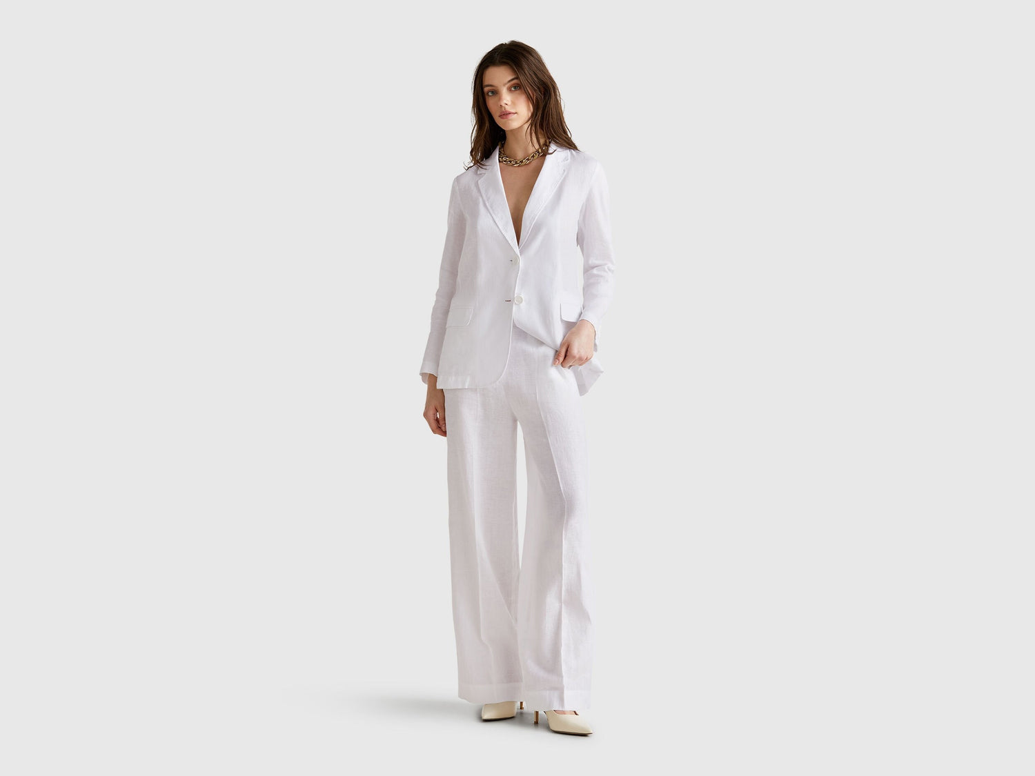 Front view of a standalone white Benetton blazer in pure linen, highlighting its timeless design and functional pockets.