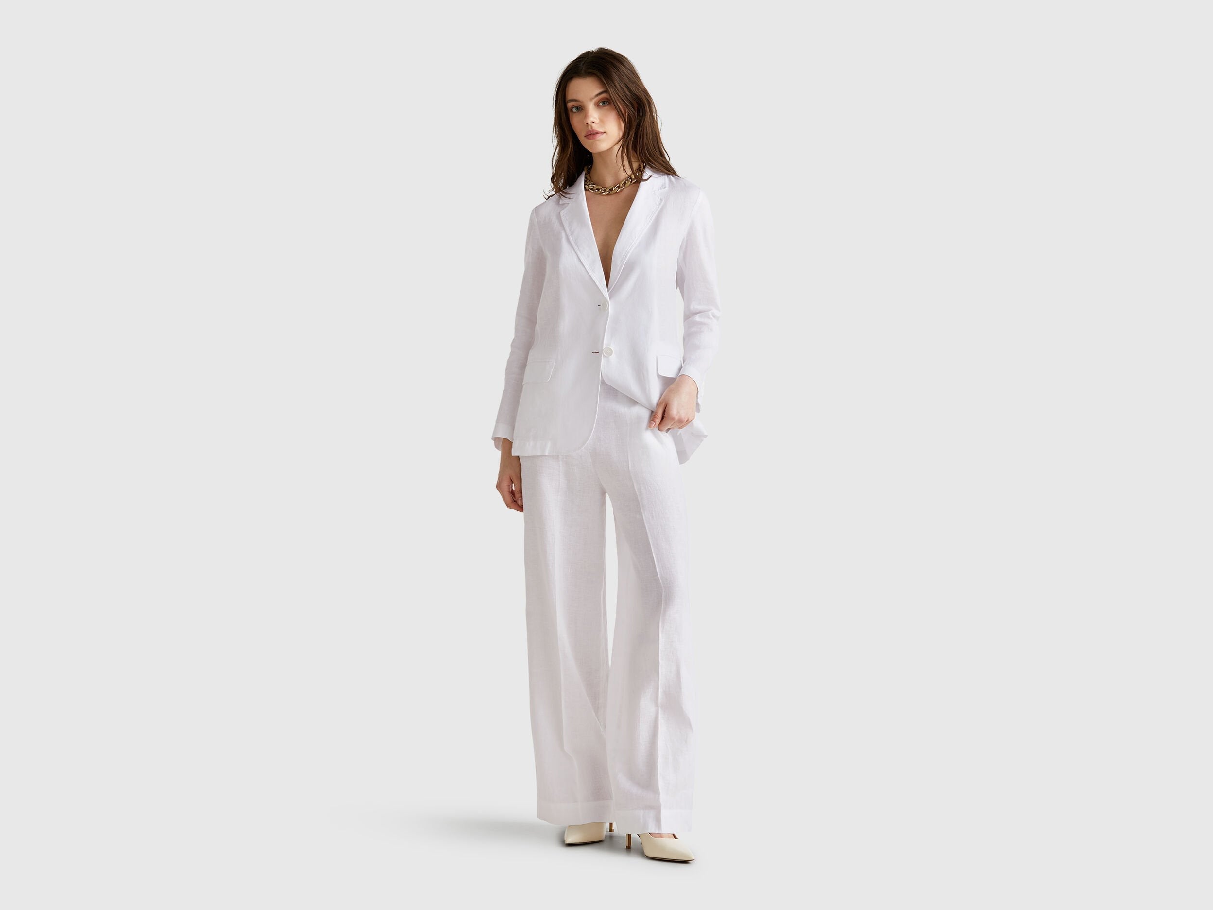 Front view of a standalone white Benetton blazer in pure linen, highlighting its timeless design and functional pockets.