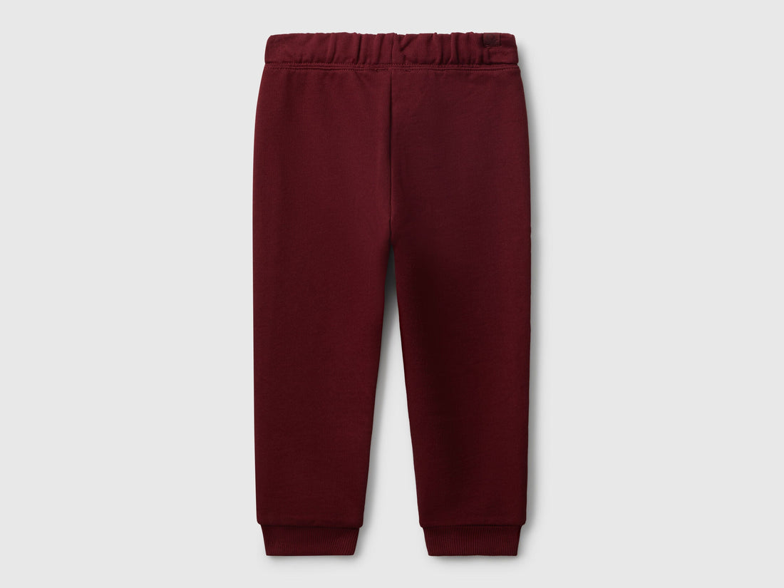 Benetton red cotton joggers side view showing elastic waist