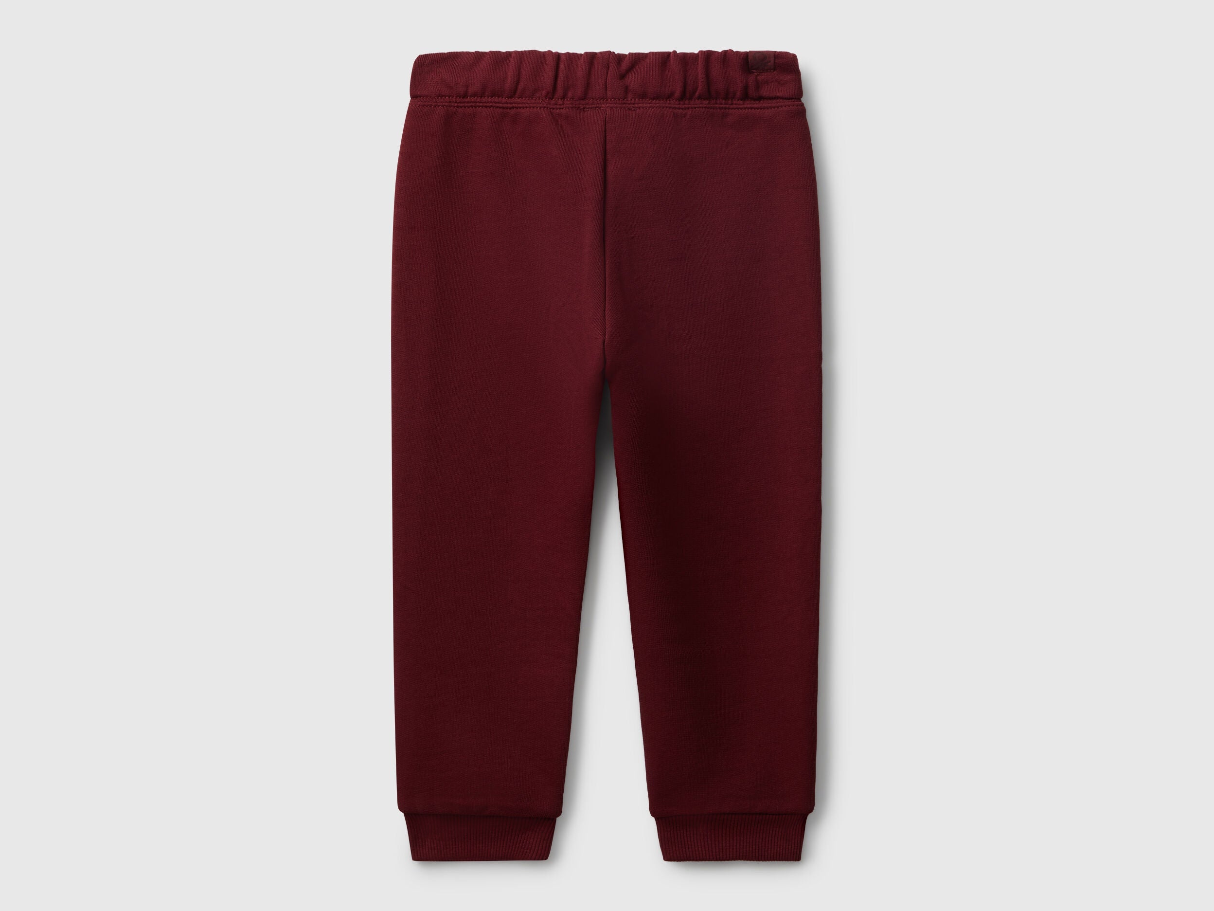 Benetton red cotton joggers side view showing elastic waist