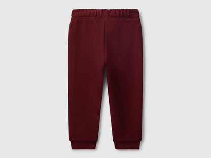 Benetton red cotton joggers side view showing elastic waist