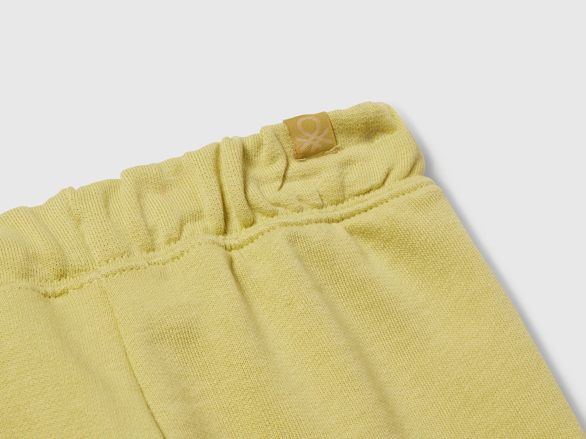 Benetton yellow cotton joggers side view showing elastic waist detail