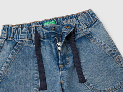 Close-up detail of the elasticized waistband, front zipper, and drawstring of Benetton Carrot Fit jeans, showing the comfortable design for Kuwait.