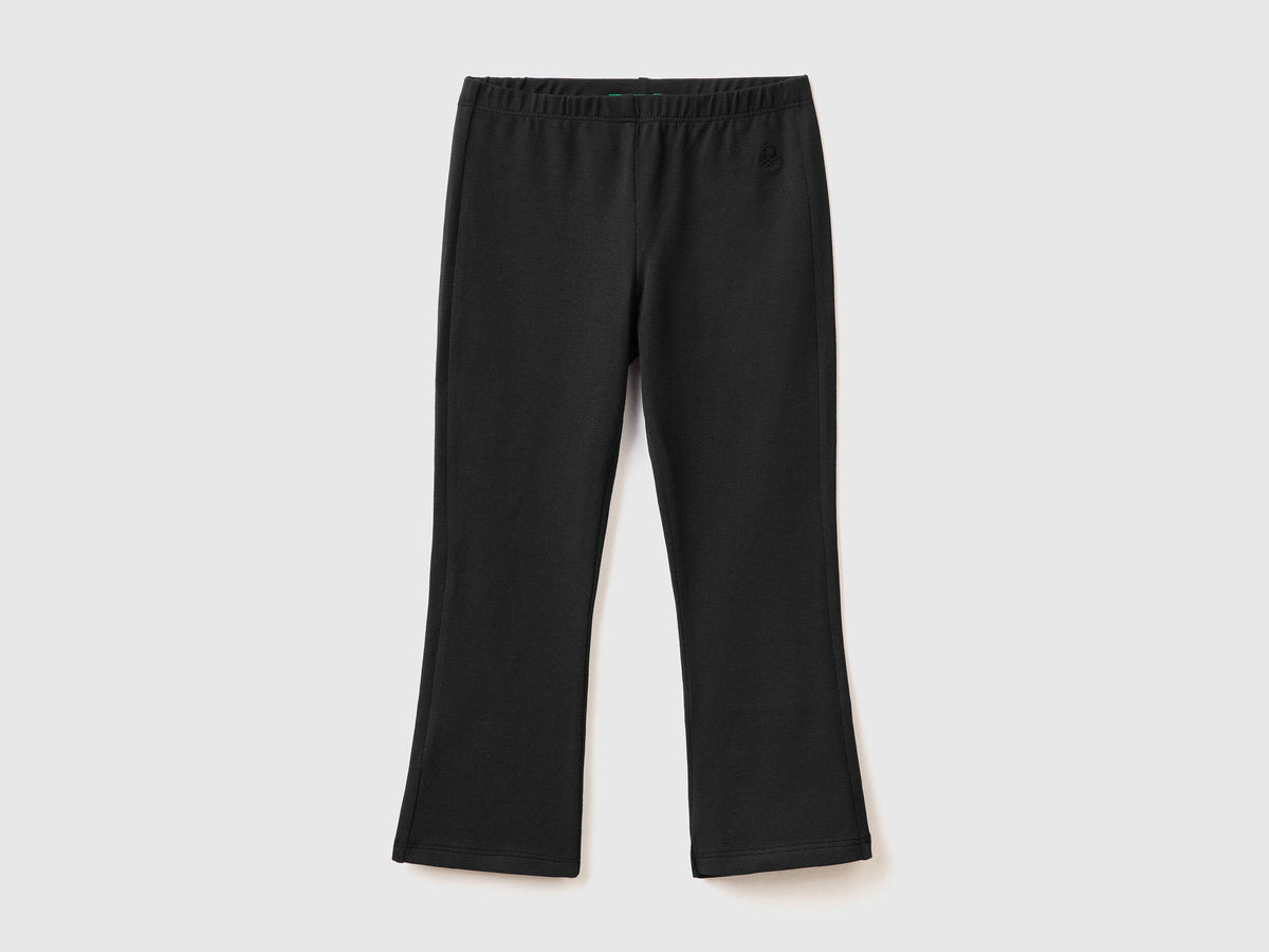 Front view of black flared leggings in stretch cotton, isolated on a light background.