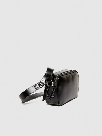 Side view of a compact black leather camera bag or messenger bag, showing its structured shape and strap attachment.