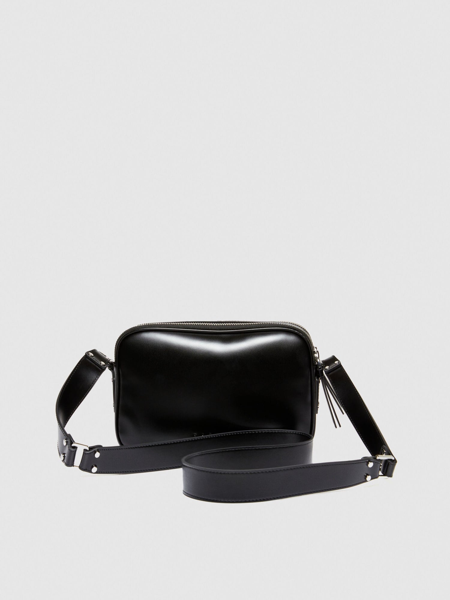 Top-angled view of a black leather camera bag or messenger bag, showcasing its compact design and the width of the strap.