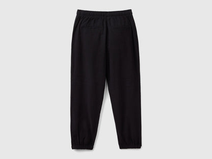 Back view of black parachute trousers with an elasticated waist and cuffs, offering a relaxed fit for casual and comfortable wear in Kuwait.
