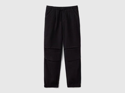 Front view of black parachute trousers with a drawstring waist and knee detailing, a comfortable and stylish choice for active wear in Kuwait.