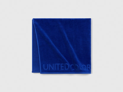 Close-up of blue Benetton beach towel, highlighting its woven texture and subtle pattern.