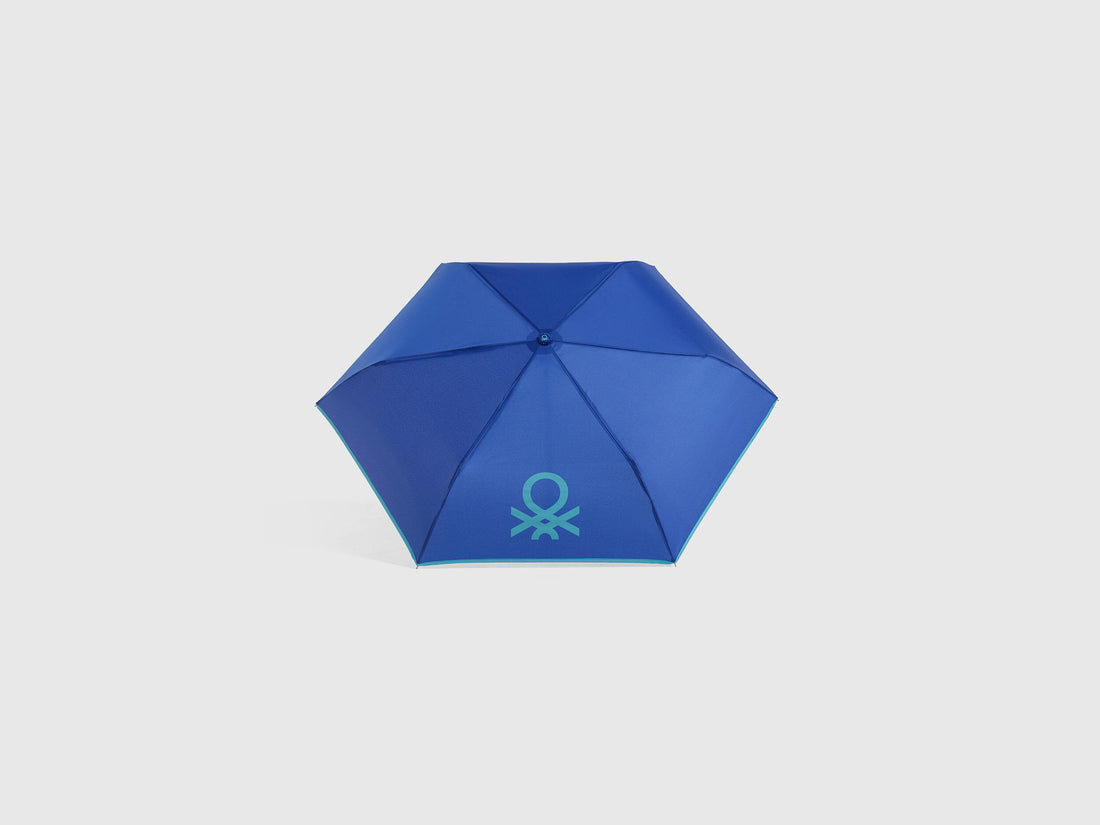 Open blue Benetton umbrella, top view for rain protection.