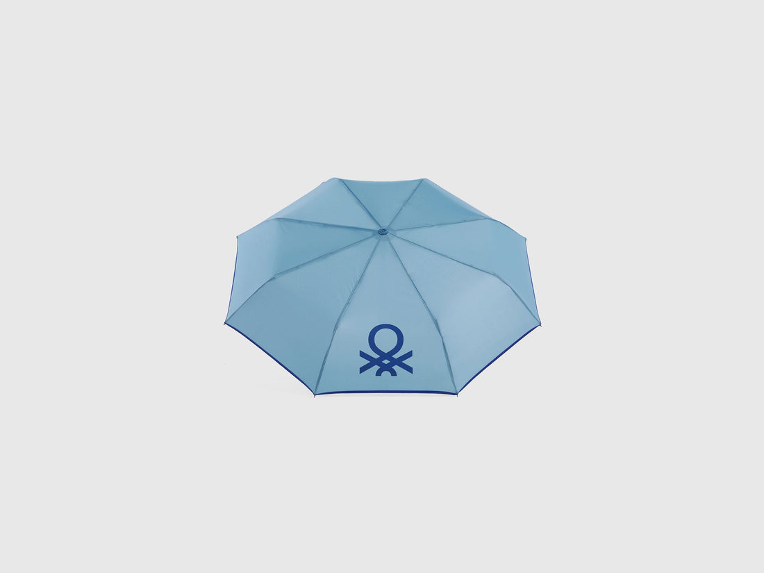 Open blue Benetton umbrella, top view for rain protection.