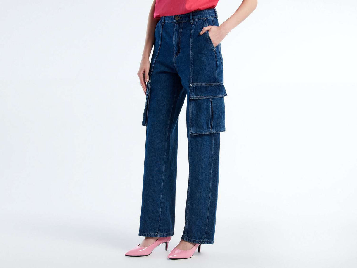 Side view of a woman wearing dark blue cargo trousers and pink heels. Features large side pockets.