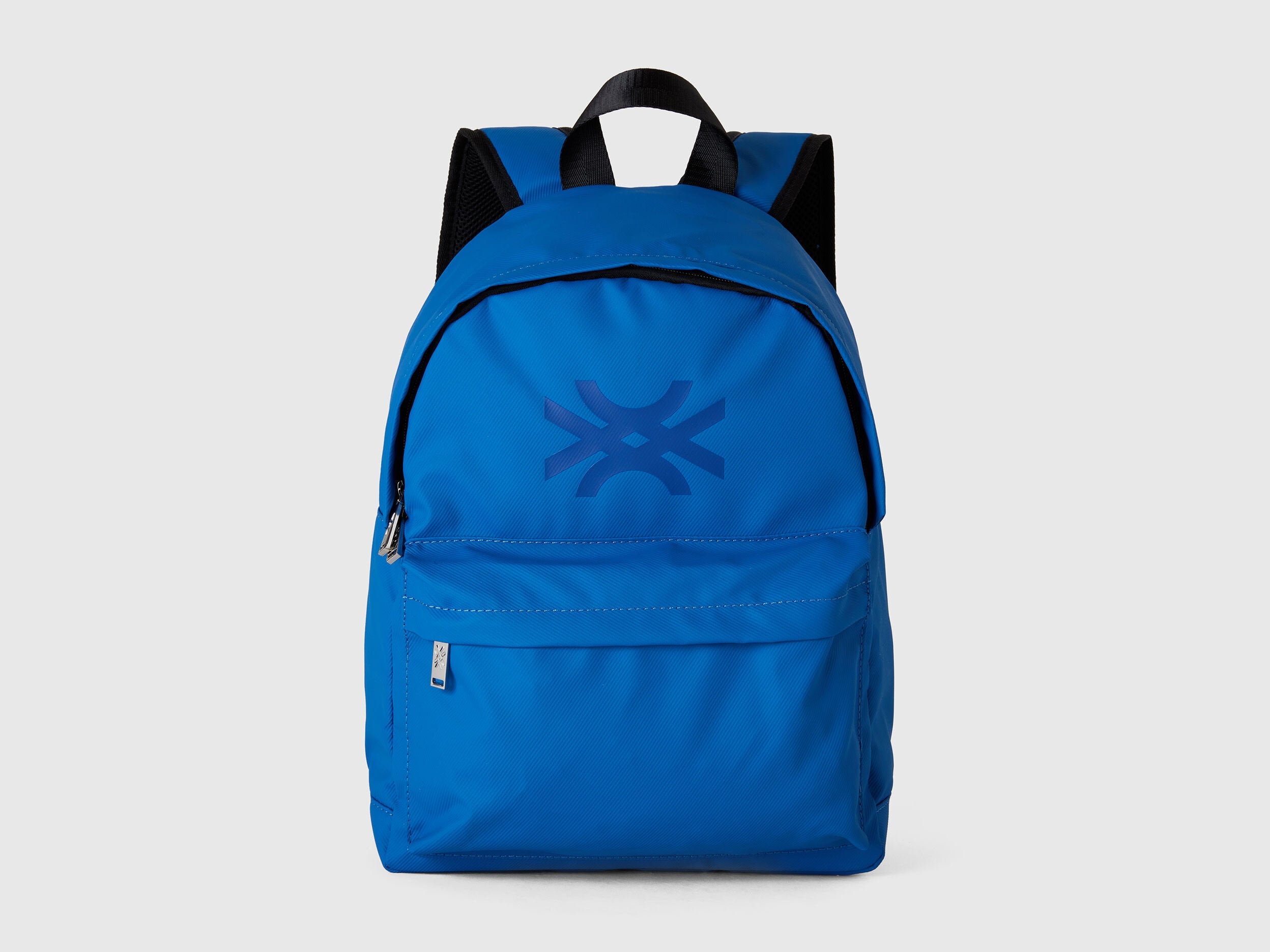 Front view of a vibrant blue nylon backpack with a prominent Benetton logo on the flap.