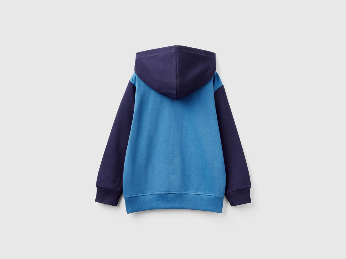 Back view of a color-block zip-up hoodie in dark blue and light blue. Soft fabric.
