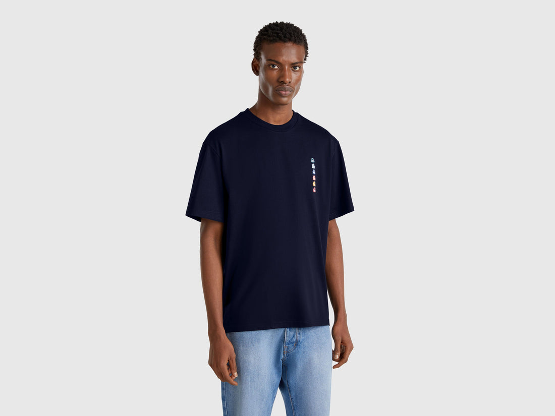 Front view of a dark blue oversized t-shirt with a white rectangular patch on the chest.
